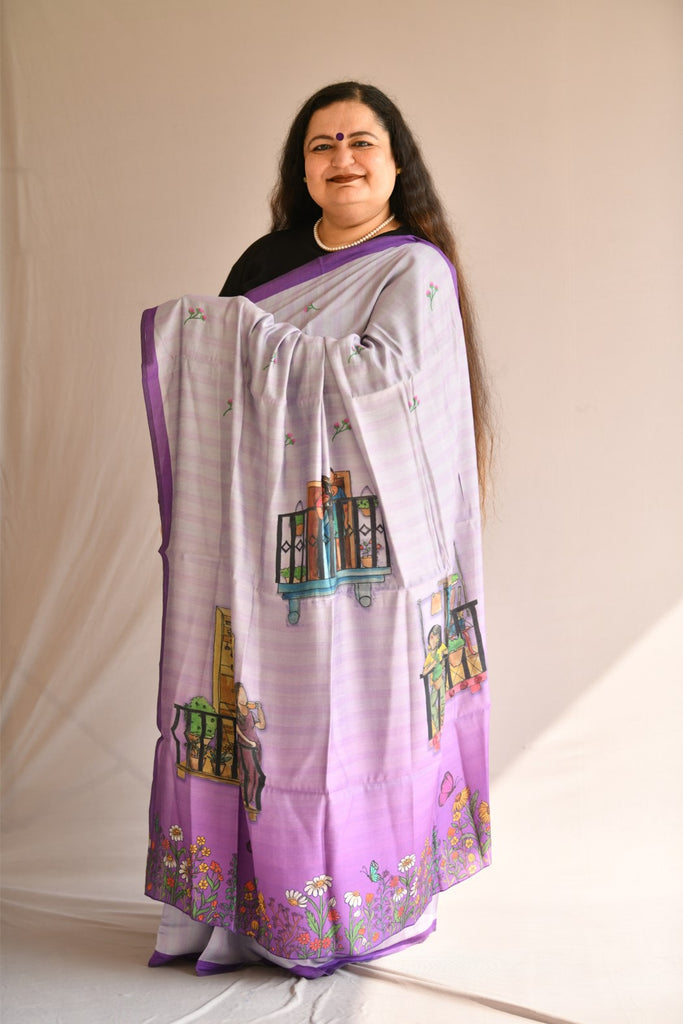 Front pose of a female model in light purple and mauve Chanderi silk saree with printed flowers and women at leisure in their balconies